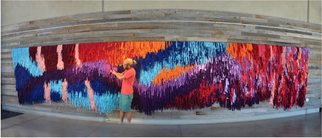 Steven working on the 35 foot long Tapestry of Changed lives that he helped ideate, design, and lead.